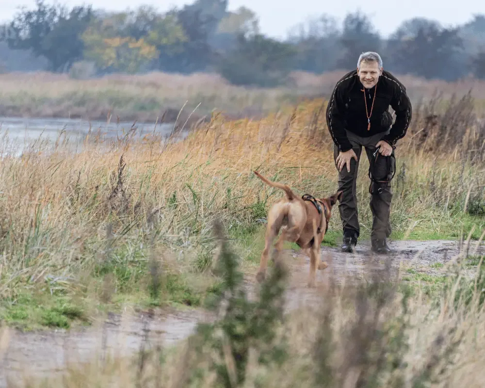 mann ruft seinen hund herbei